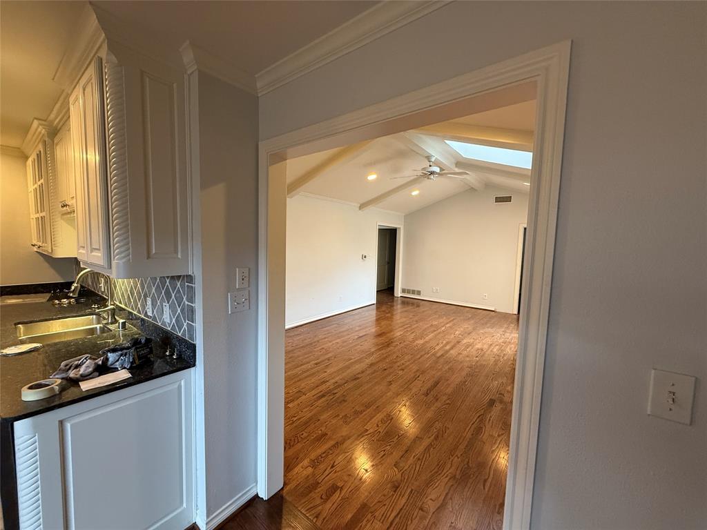 4916 Sugar Mill Road Dallas, TX 75244 - Photo 6 of 18 Kitchen and Den featuring dark wood-type flooring, crown molding, and a skylight