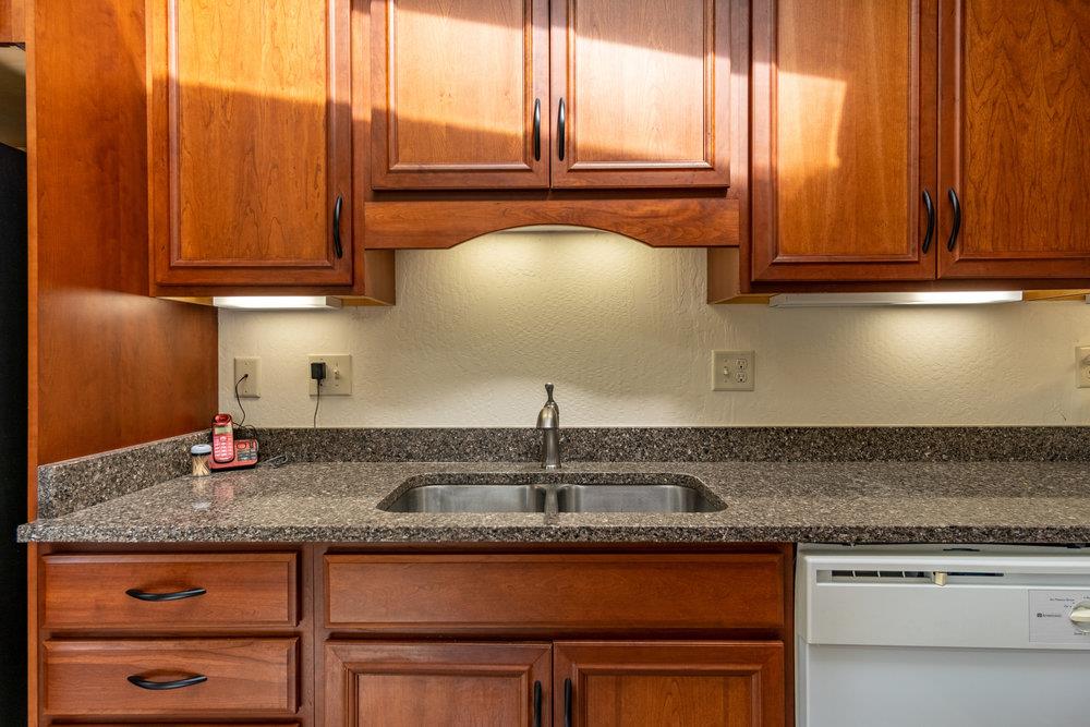 102 Smith Road Watsonville, CA 95076 - Photo 10 of 41 a kitchen with granite countertop wooden cabinets a sink and dishwasher