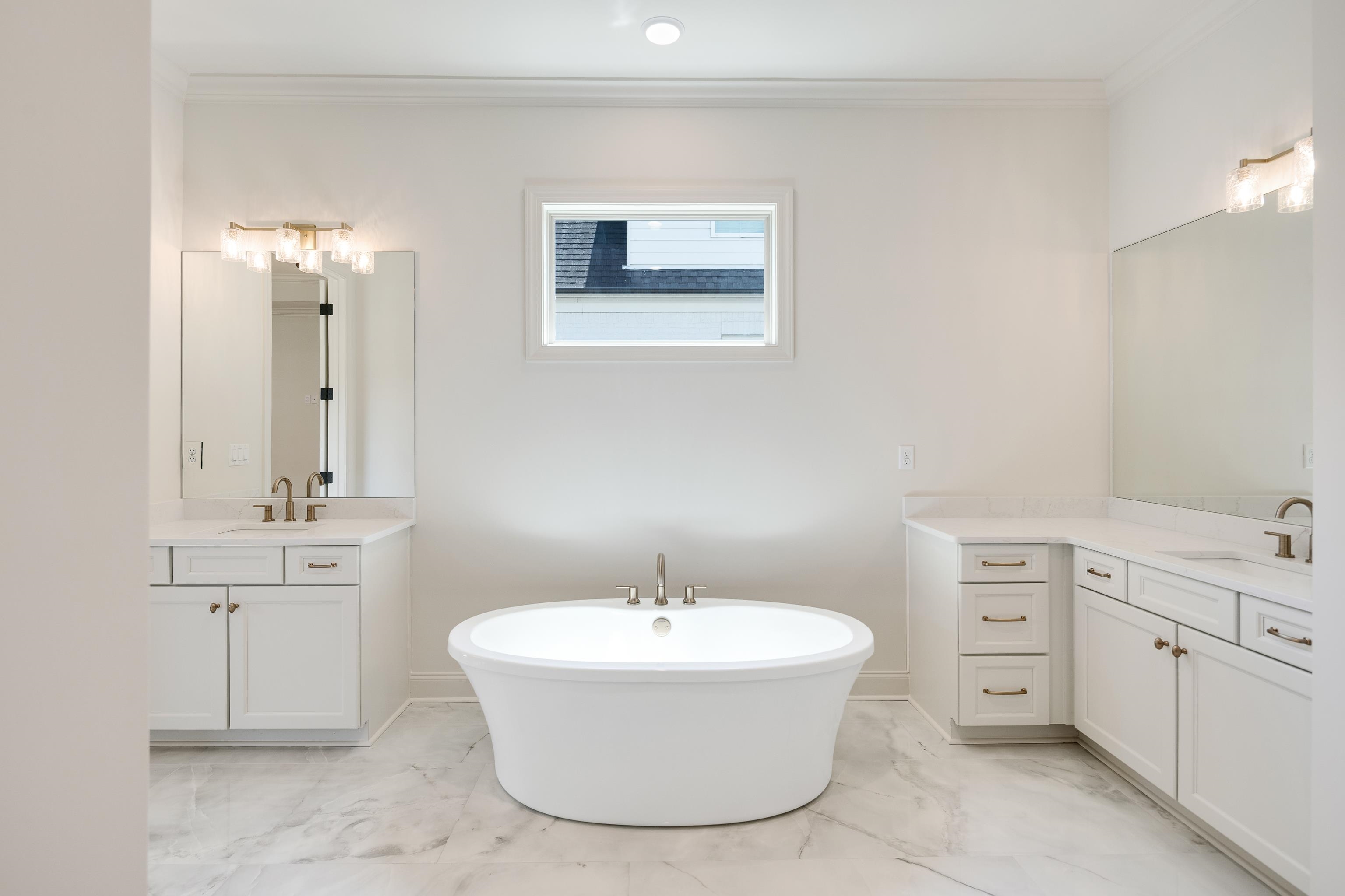 3406 Village Cross Loop Collierville, TN 38017 - Photo 18 of 40 Freestanding soaking tub, dual vanities with white cabinetry, light-toned countertops, large mirrors, and decorative light fixtures