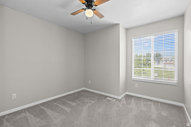 142 East 2675th Street South Clearfield, UT 84015 - Photo 23 of 49 Neutral wall paint, gray carpeting, white trim, a ceiling fan with integrated lighting, and a window with blinds