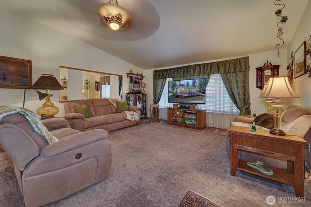 a living room with furniture a chandelier and a flat screen tv