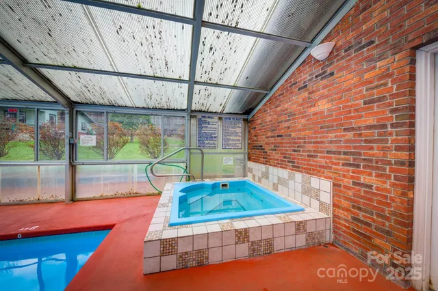 a view of swimming pool with seating area and trees in the background