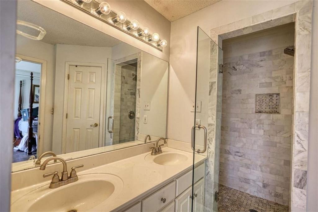 3588 Old Hamilton Mill Road Northeast Buford, GA 30519 - Photo 20 of 49 a bathroom with a granite countertop double vanity sink mirror and shower