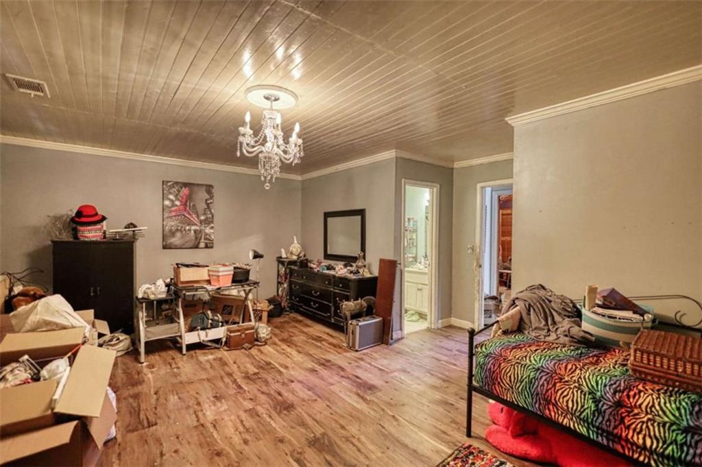 3588 Old Hamilton Mill Road Northeast Buford, GA 30519 - Photo 35 of 49 a bedroom with bed and a chandelier