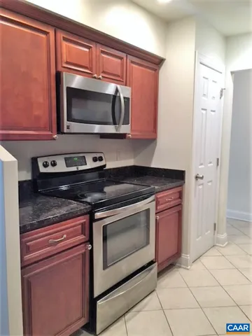 a kitchen with stainless steel appliances granite countertop a stove microwave and sink