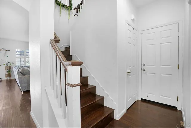 a view of entryway and hall with wooden floor