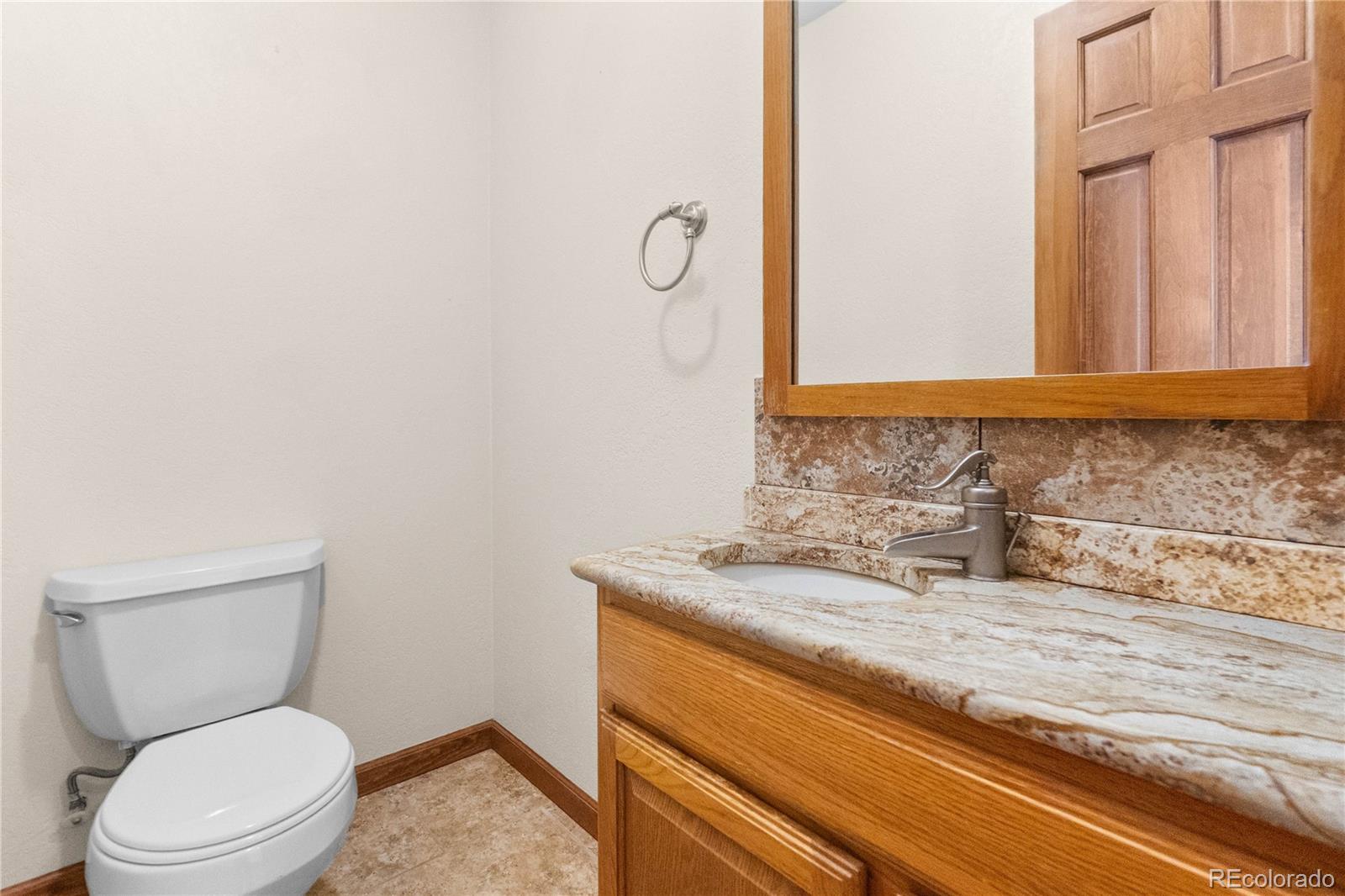 74 Rocky Cliff Road Elizabeth, CO 80107 - Photo 19 of 50 a bathroom with a granite countertop toilet and a sink