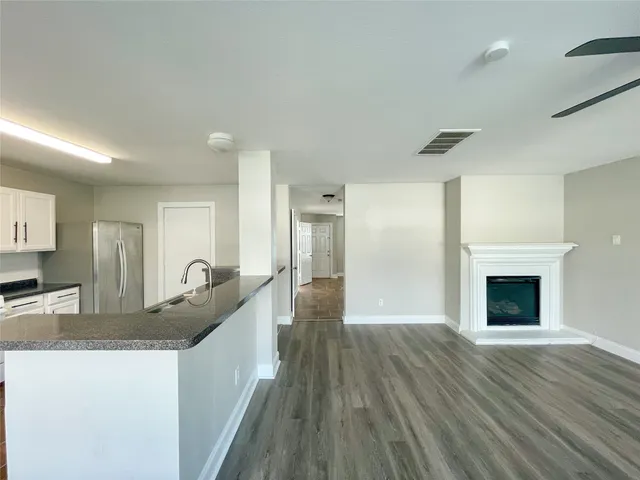 a view of kitchen with granite countertop kitchen island wooden floors and stainless steel appliances