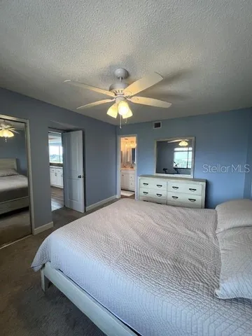 a spacious bathroom with a granite countertop sink toilet a mirror and shower