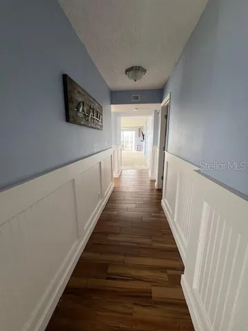 a view of a hallway with wooden floor and stairs