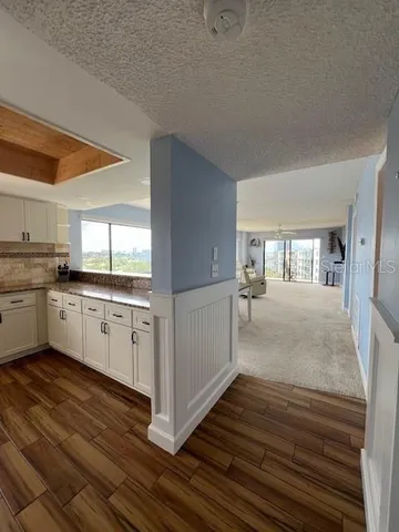 a kitchen with granite countertop white cabinets and white appliances