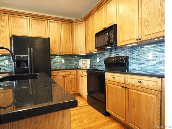 a kitchen with stainless steel appliances granite countertop a sink a stove and cabinets