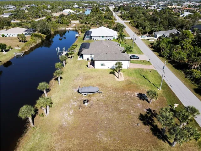 an aerial view of a house with a yard and lake view
