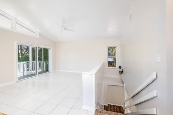 an empty room with windows and fan