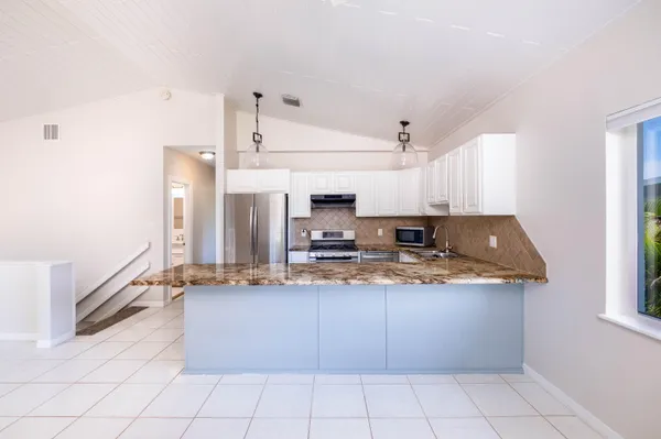 a view of a kitchen with furniture and an empty room