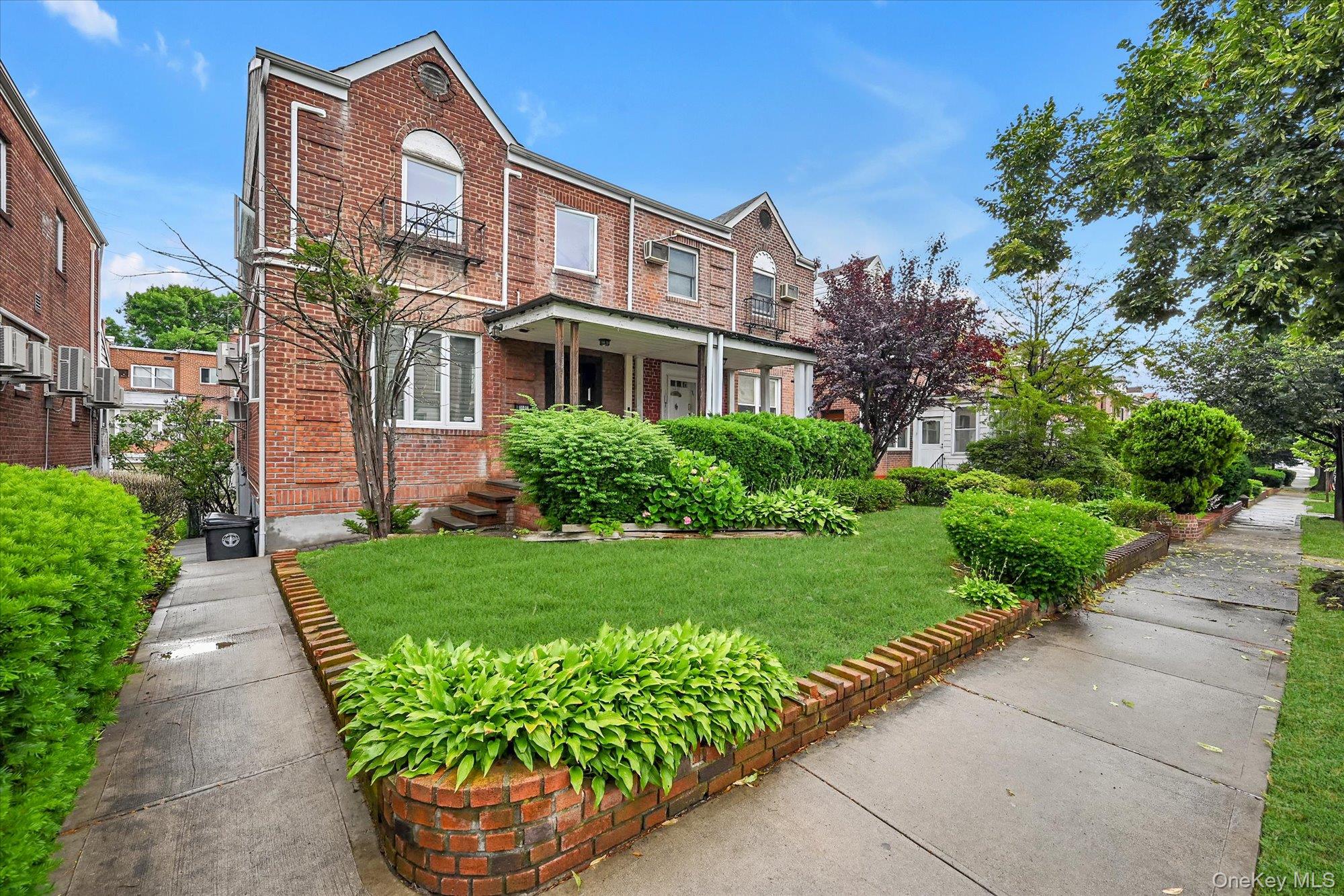 144-11 70th Road Queens, NY 11367 - Photo 1 of 1 View of front facade with brick siding and a front yard