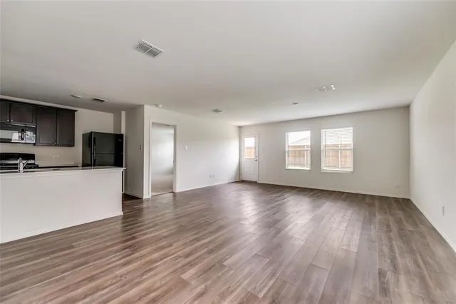 a view of a kitchen with wooden floor and a refrigerator