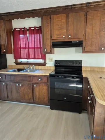a kitchen with granite countertop a stove and a sink