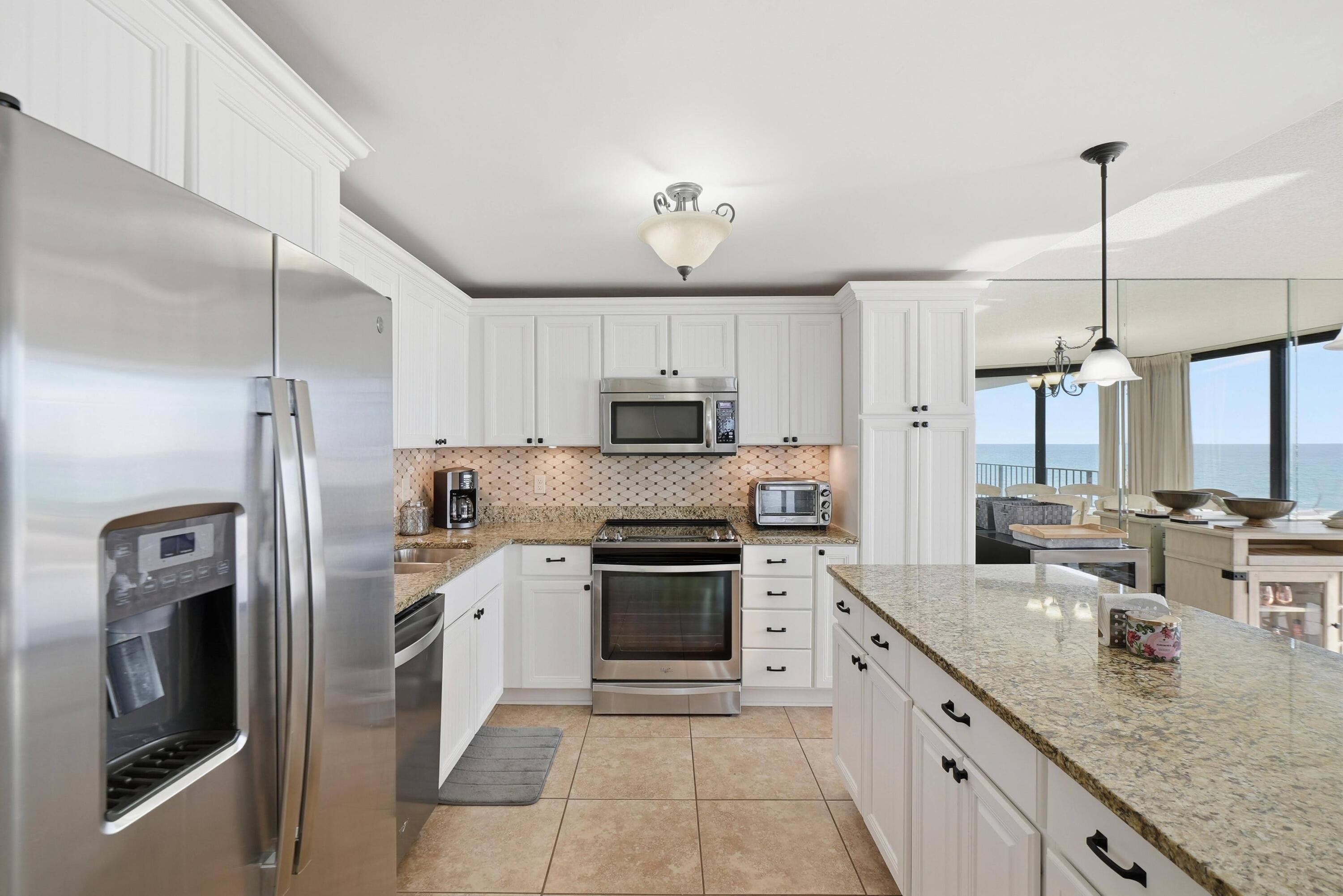 11619 Front Beach Road, Unit 212 Panama City Beach, FL 32407 - Photo 14 of 63 a kitchen with stainless steel appliances granite countertop a sink a stove and a refrigerator