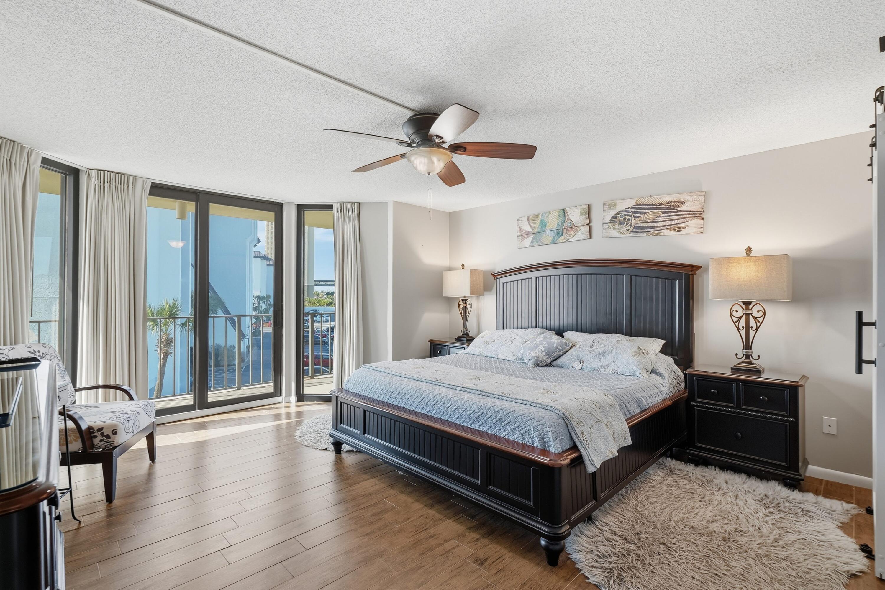 11619 Front Beach Road, Unit 212 Panama City Beach, FL 32407 - Photo 16 of 63 a bedroom with a large bed and a chandelier fan