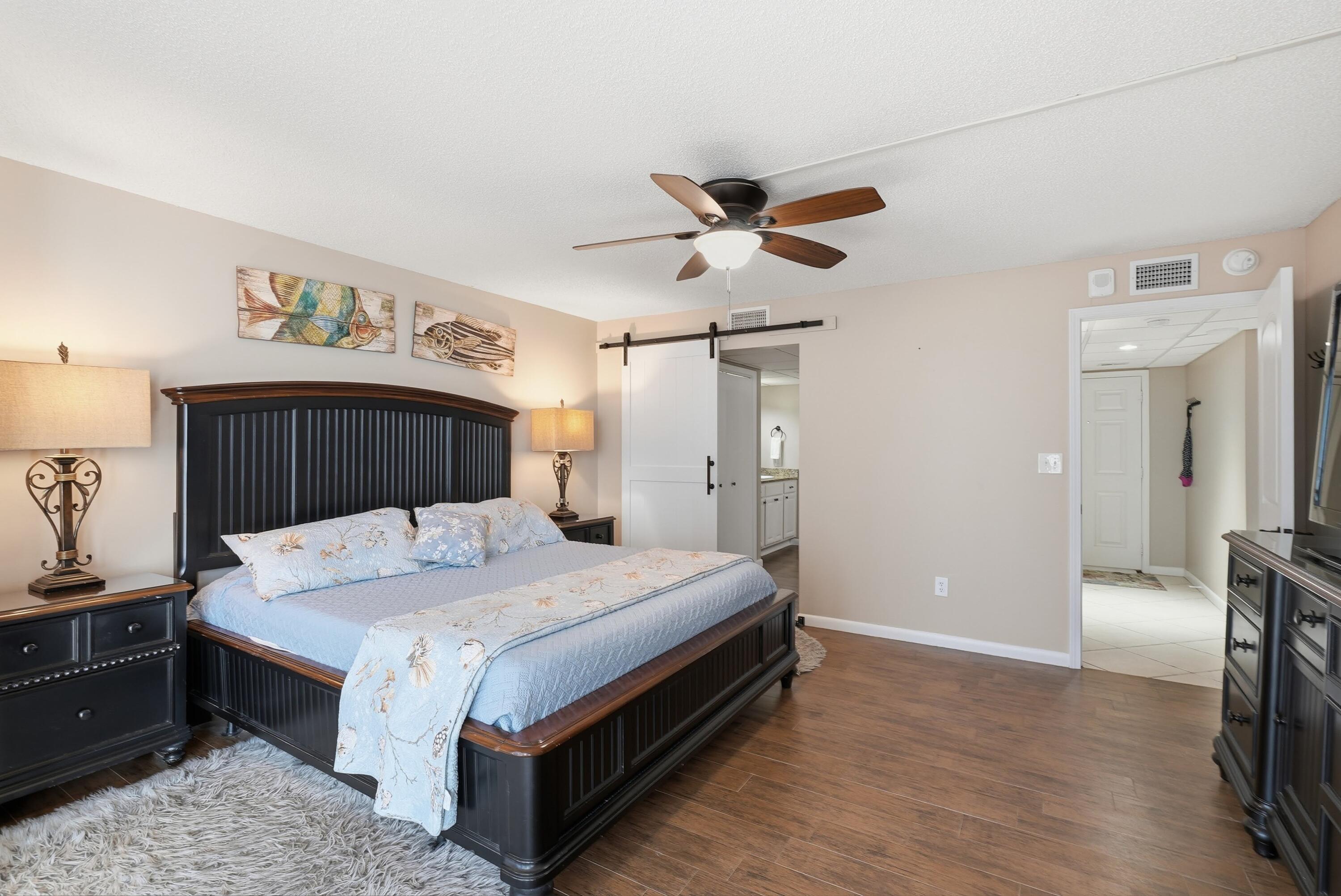 11619 Front Beach Road, Unit 212 Panama City Beach, FL 32407 - Photo 17 of 63 a bedroom with a bed and a chandelier
