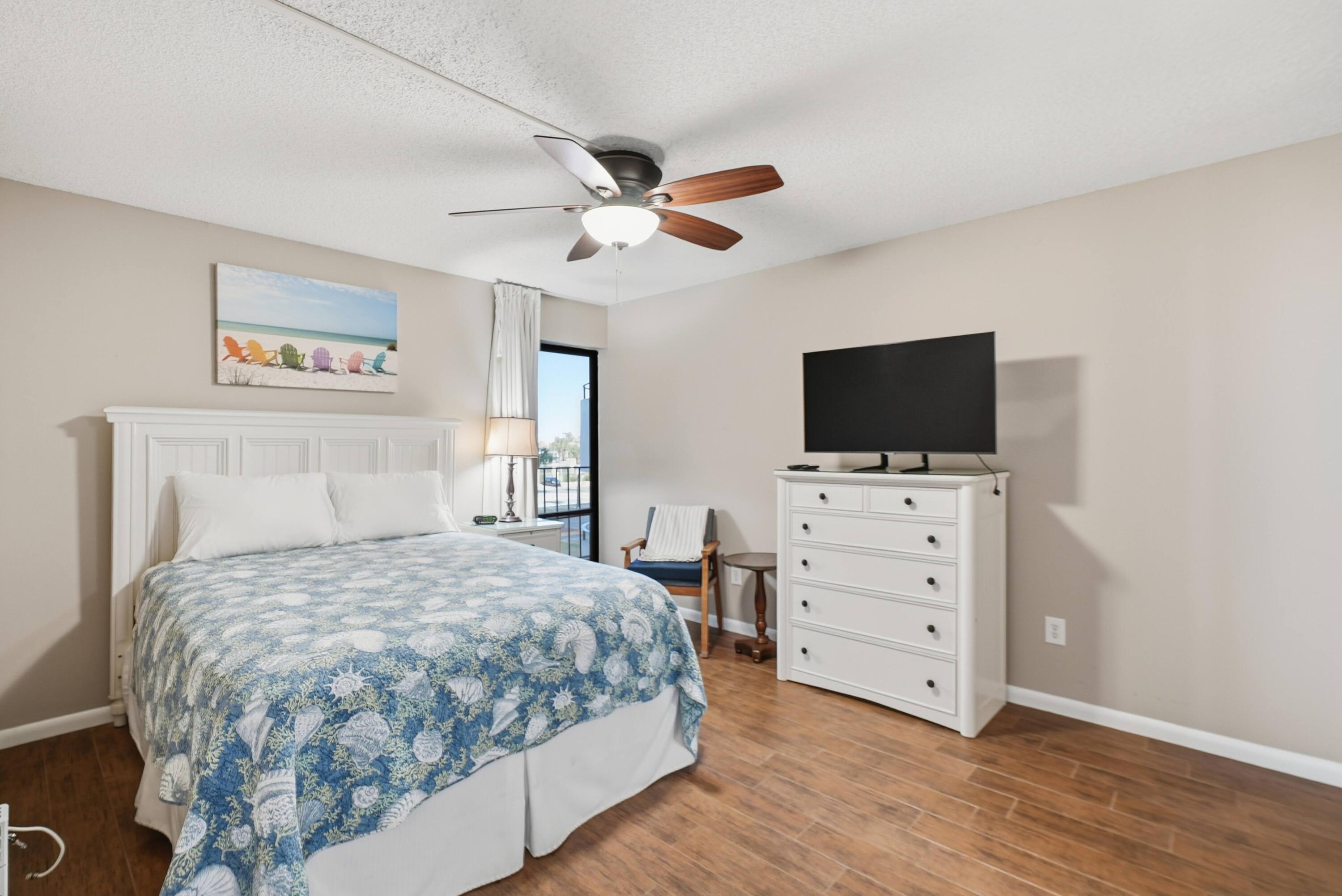 11619 Front Beach Road, Unit 212 Panama City Beach, FL 32407 - Photo 31 of 63 a bedroom with a bed and a flat screen tv