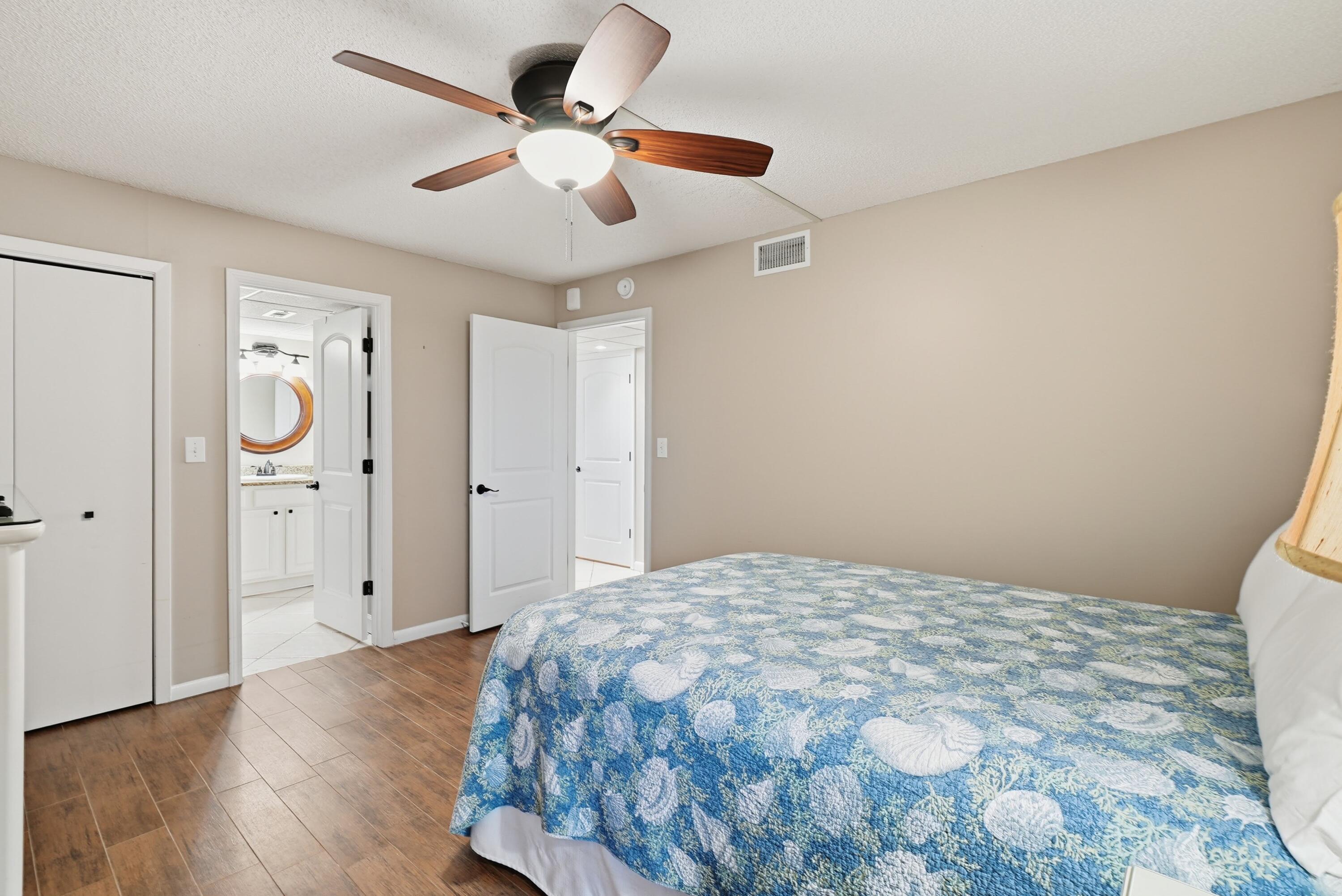 11619 Front Beach Road, Unit 212 Panama City Beach, FL 32407 - Photo 32 of 63 a bedroom with a bed and a chandelier