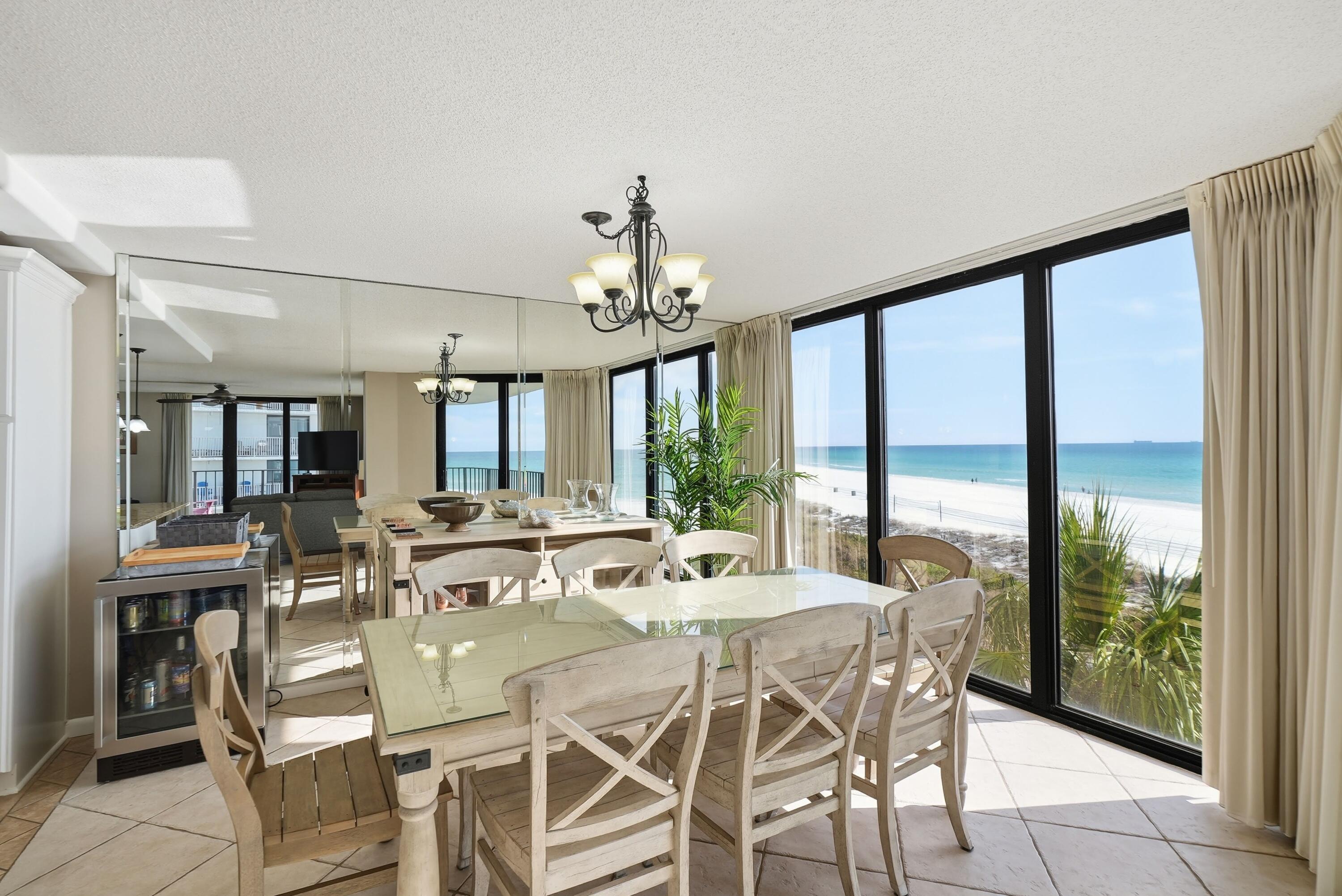 11619 Front Beach Road, Unit 212 Panama City Beach, FL 32407 - Photo 9 of 63 a view of a dining room with furniture large windows and wooden floor