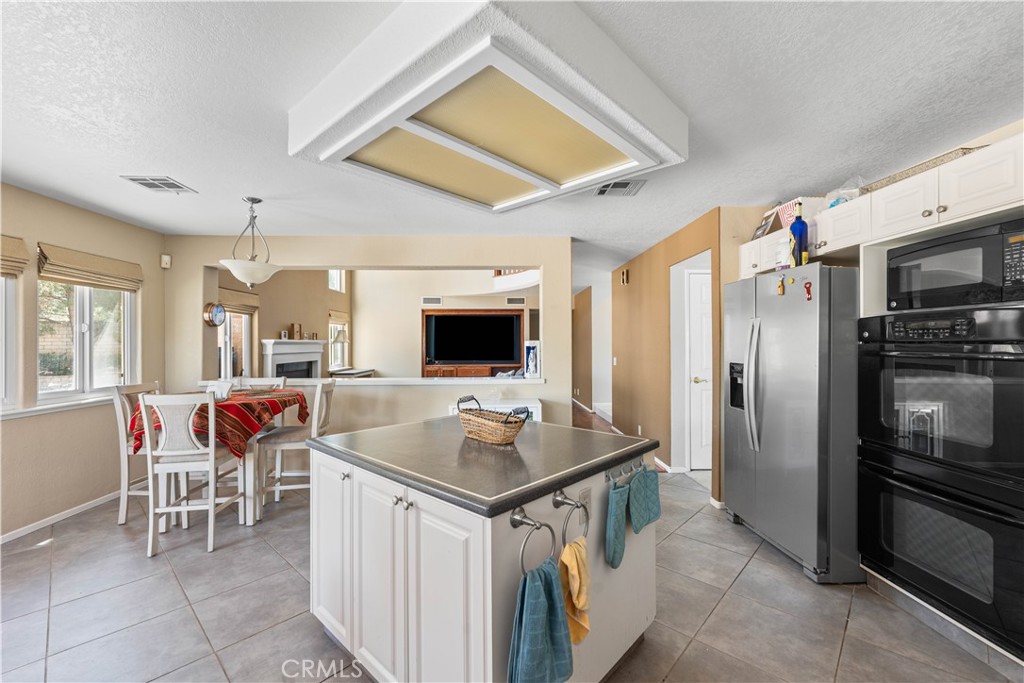 41058 Carmel Road Palmdale, CA 93551 - Photo 23 of 68 a open kitchen with stainless steel appliances granite countertop a stove refrigerator and a dining table with the kitchen view