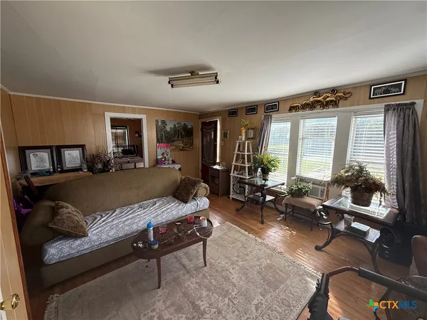 a living room with furniture a flat screen tv and a large window