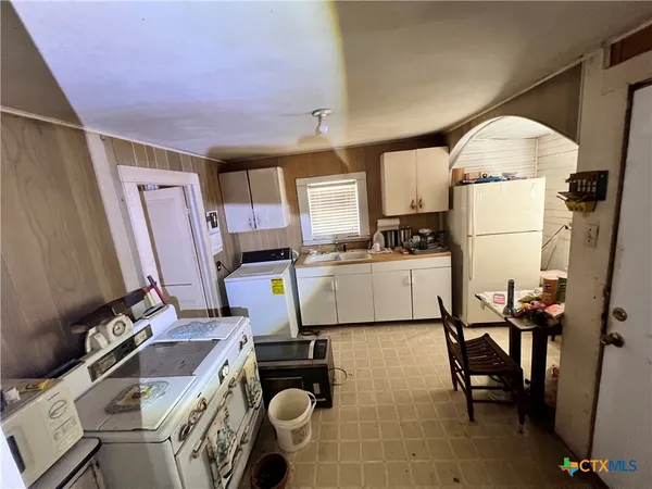 a kitchen with a table chairs refrigerator and microwave