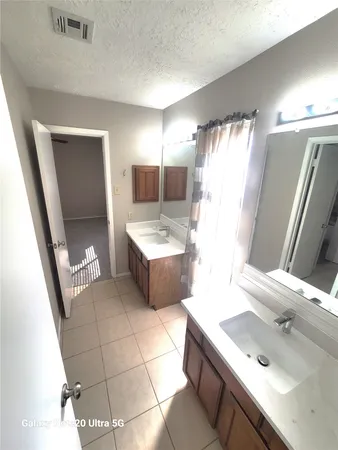 a en suite bathroom with a double vanity sink a mirror and a bathtub