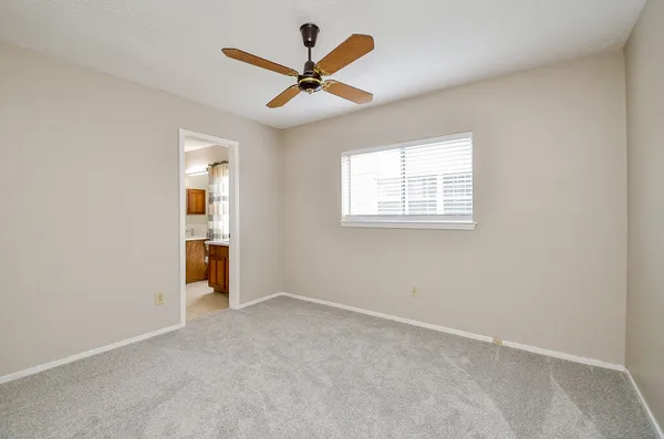an empty room with a ceiling fan and a window