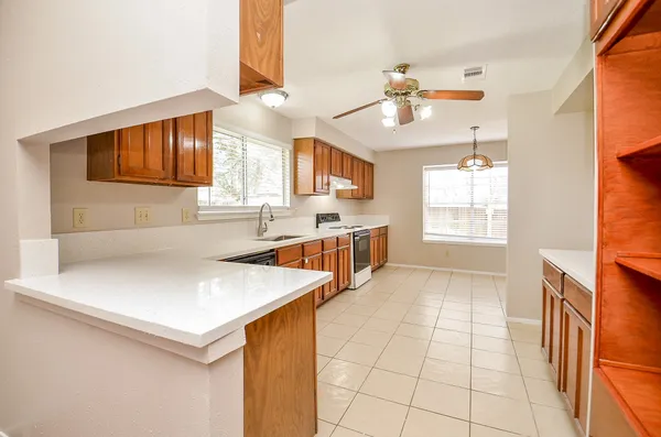 a kitchen with stainless steel appliances a sink a stove cabinets and a window