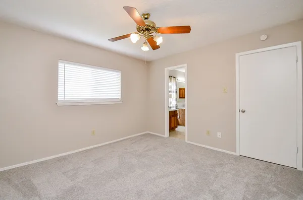 an empty room with closet and fan