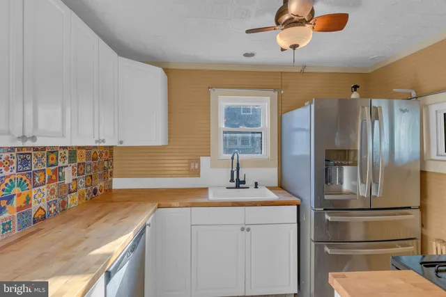 a kitchen with stainless steel appliances granite countertop a refrigerator a stove and a sink