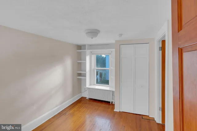 a view of a room with wooden floor and window