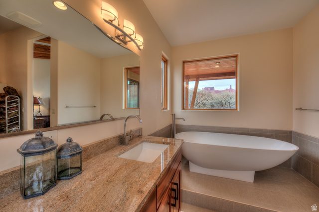 425 Amber Lane Moab, UT 84532 - Photo 12 of 27 Bathroom with vanity, wainscoting, tile walls, and a soaking tub