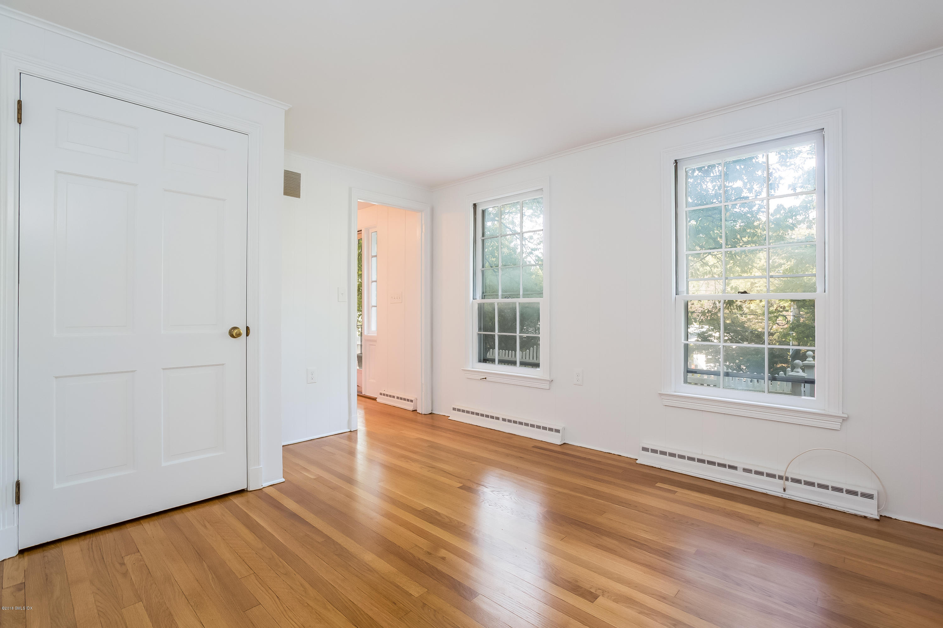 8 Skylark Road Greenwich, CT 06830 - Photo 5 of 15 an empty room with wooden floor and windows