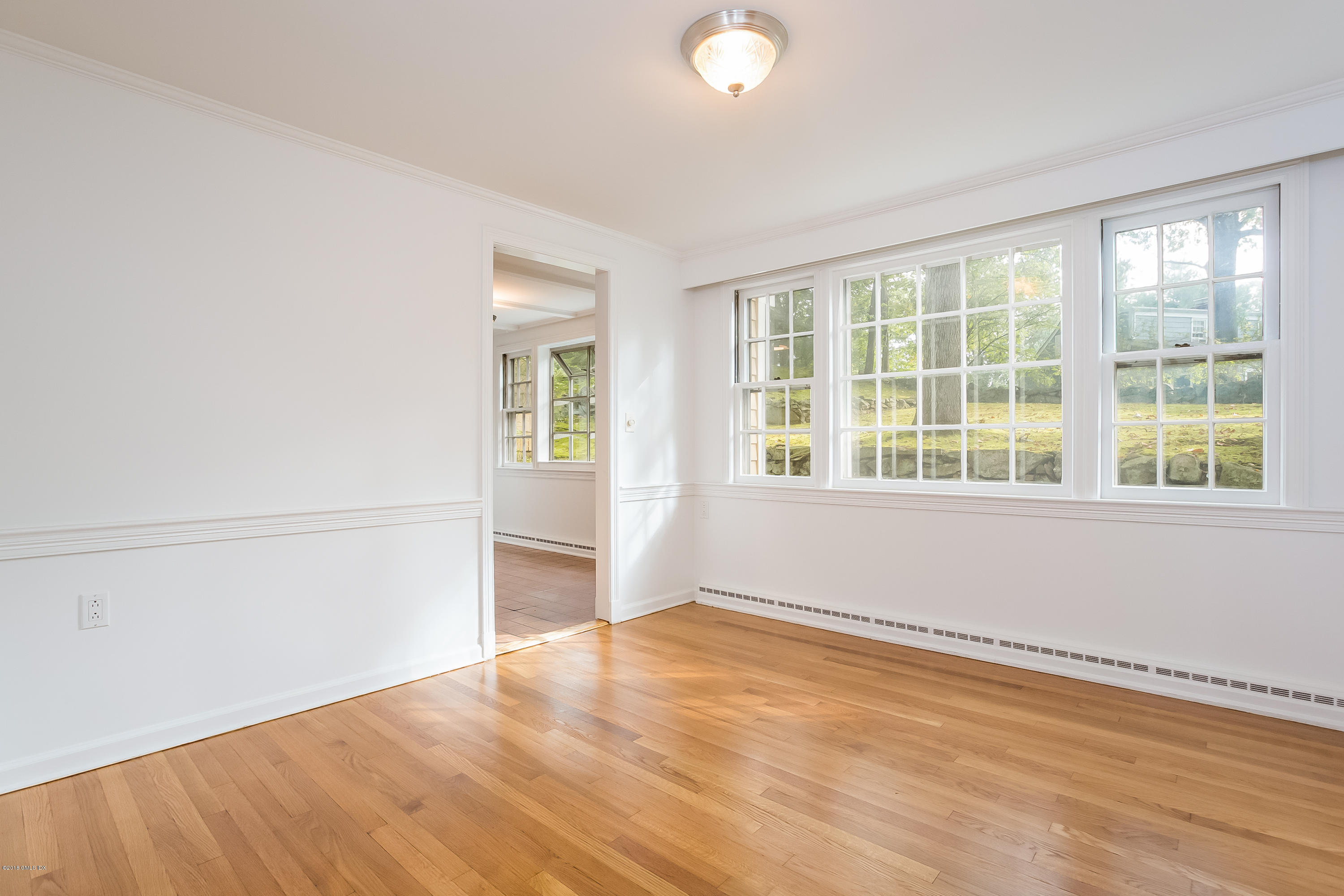 8 Skylark Road Greenwich, CT 06830 - Photo 7 of 15 an empty room with wooden floor and windows