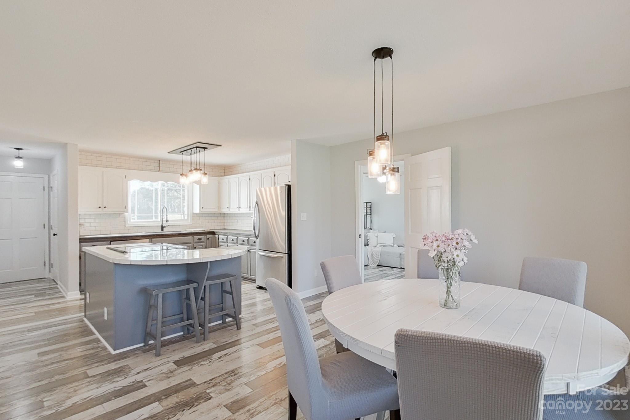 8176 Renee Ford Road Stanfield, NC 28163 - Photo 15 of 48 a kitchen with a dining table chairs a sink and a stove