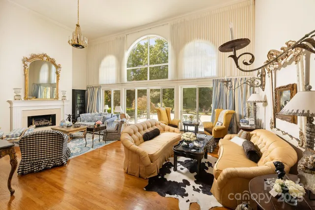 a living room with fireplace furniture and a large window