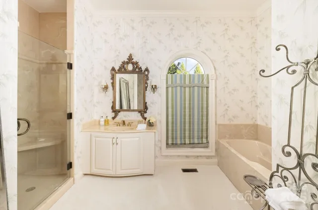 a spacious bathroom with a tub sink and mirror