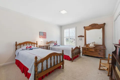 a bedroom with two beds and window