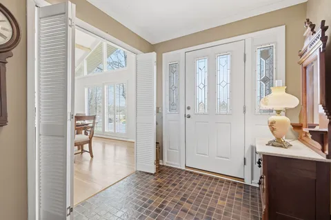 a view of a hallway with bathroom and wooden floor