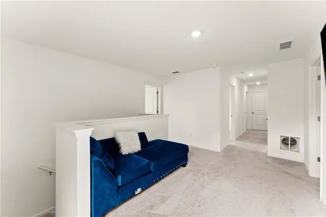 a living room with furniture and a walk in closet with wooden floor