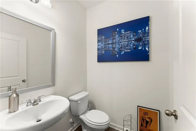 a bathroom with a toilet a sink and mirror