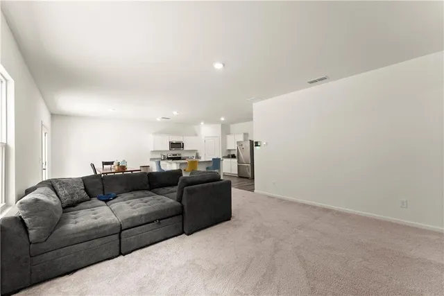 a living room with couches and kitchen view