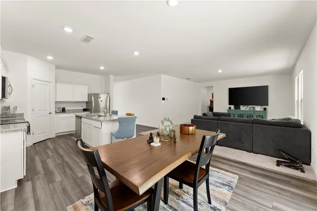 a living room with furniture a flat screen tv and kitchen view