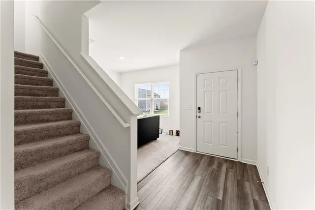 a view of entryway and hall with wooden floor